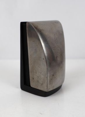 un objet métallique posé sur une surface blanche