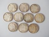 six types de pièces différents sont disposés en cercle sur une surface blanche