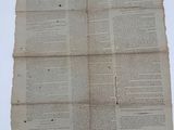 an old newspaper with a piece of paper on top of it