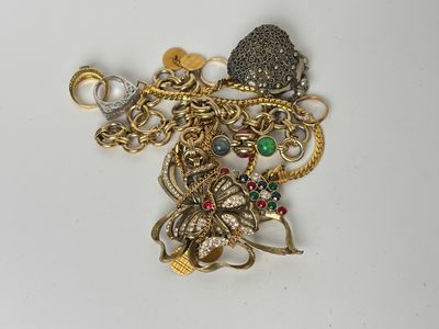 un tas de bijoux en or et en argent posés sur une surface blanche