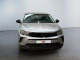 the front view of a silver suv parked in a showroom
