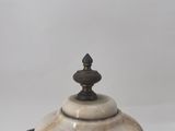 an image of a white marble covered dish with a metal lid