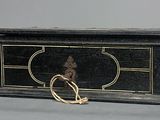 a small black box with a gold ring on it