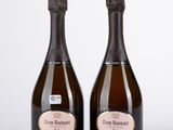 deux bouteilles de champagne posées l'une à côté de l'autre sur une table