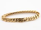 gros plan d'un bracelet en or sur fond blanc