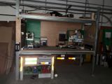a garage with a work bench and a shelf with tools