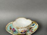 two small cups and saucers with floral designs on them
