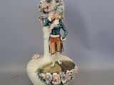 un vase orné d'une figurine représentant un homme et une femme