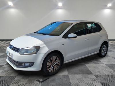 la volkswagen polo blanche est garée dans une pièce au sol en damier