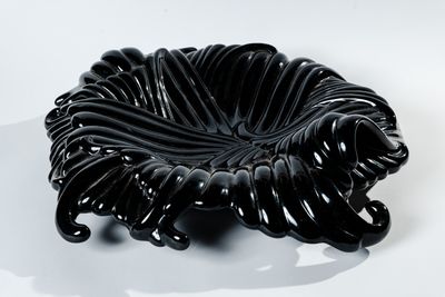 une image représentant un bol noir posé sur une surface blanche