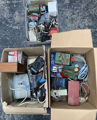 two boxes full of electronic devices sitting on the ground