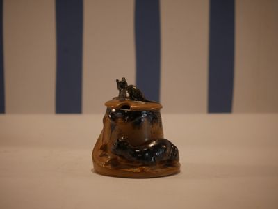 a small figurine of a cat sitting on a rock