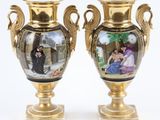 deux vases ornés de portraits, posés sur une table