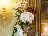 un vase de fleurs posé sur une table devant une cheminée