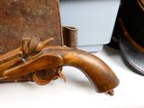 a wooden gun that is on a table next to a hat