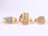 three gold and silver rings on a white surface with a white background