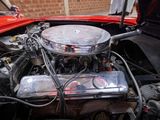 a red car with a chrome engine in it