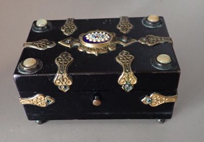 a small black box with gold decorations on top of it