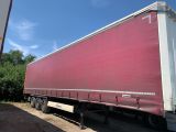 a red semi truck that is parked in front of a building