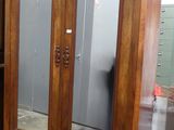 une grande armoire en bois surmontée d'un miroir