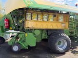 a large green tractor with a yellow trailer and some buckets on it