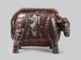 une statue d'éléphant rouge et blanche sur fond gris