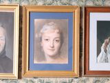 three framed portraits of older people on the wall