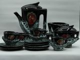 a black and red tea set sitting on a white table