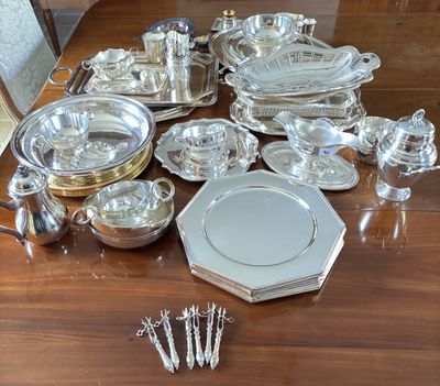 a lot of silver plates and silverware on the table
