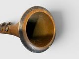 a small brass pipe with a handle on a white surface