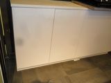 a kitchen with a stove, sink, and cabinets in it