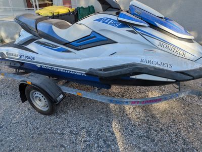 a blue and white jet ski on a trailer in front of a building