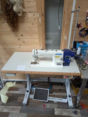 a white sewing machine sitting on a table in a room