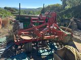 un tracteur rouge qui est garé dans la terre