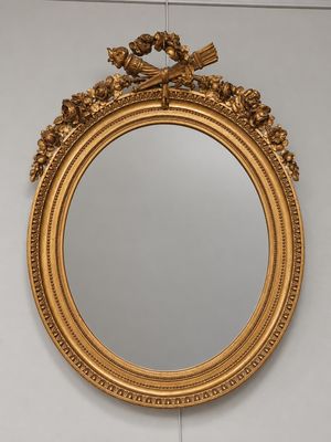 an ornate gold framed mirror hanging on a wall