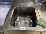 a stainless steel sink in the middle of a kitchen