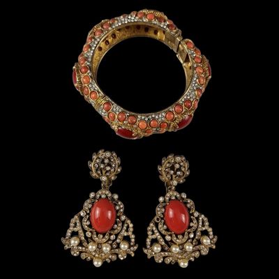 a gold and coral bracelet, ring, and earring
