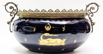 un grand vase bleu surmonté d'une couronne dorée