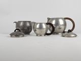 three silverplated teapots and a teapot on a white surface