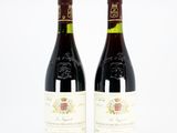 deux bouteilles de vin rouge posées l'une à côté de l'autre sur une surface blanche
