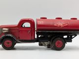 a toy truck with a red tank on the back of it