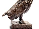 a statue of a bird that is sitting on top of a block