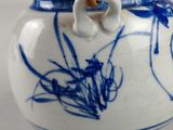 a blue and white vase with two bamboo sticks sticking out of it
