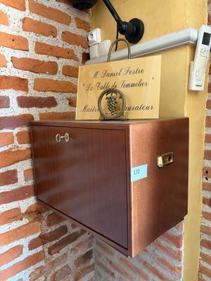 a wall mounted cabinet with a clock on top of it