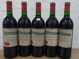 quatre bouteilles de vin rouge sont alignées sur une table