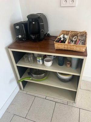 a coffee maker and other items on a shelf in a kitchen