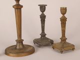 three antique brass candlesticks are sitting next to each other