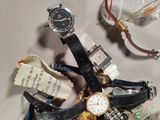 a pile of assorted watches and glasses on a table