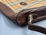 a brown purse with a brown strap on a blue table