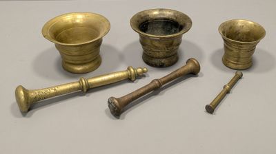 several brass objects are sitting on a table with a white background